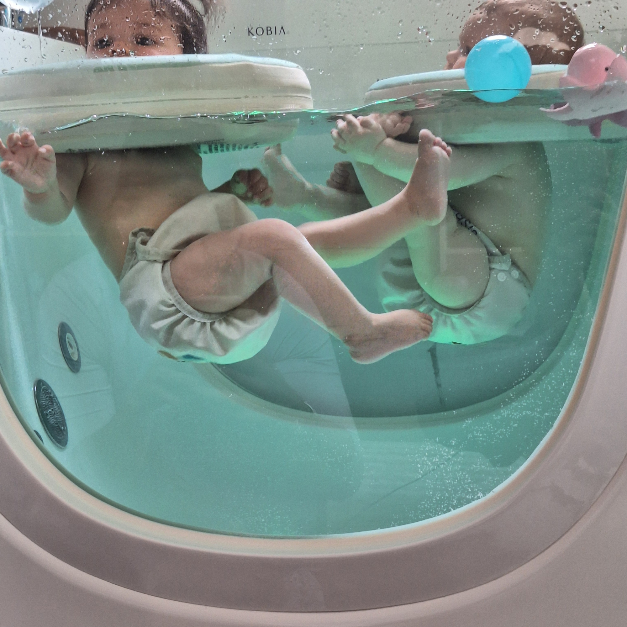 Séance de baby spa vue à travers la vitre du salon