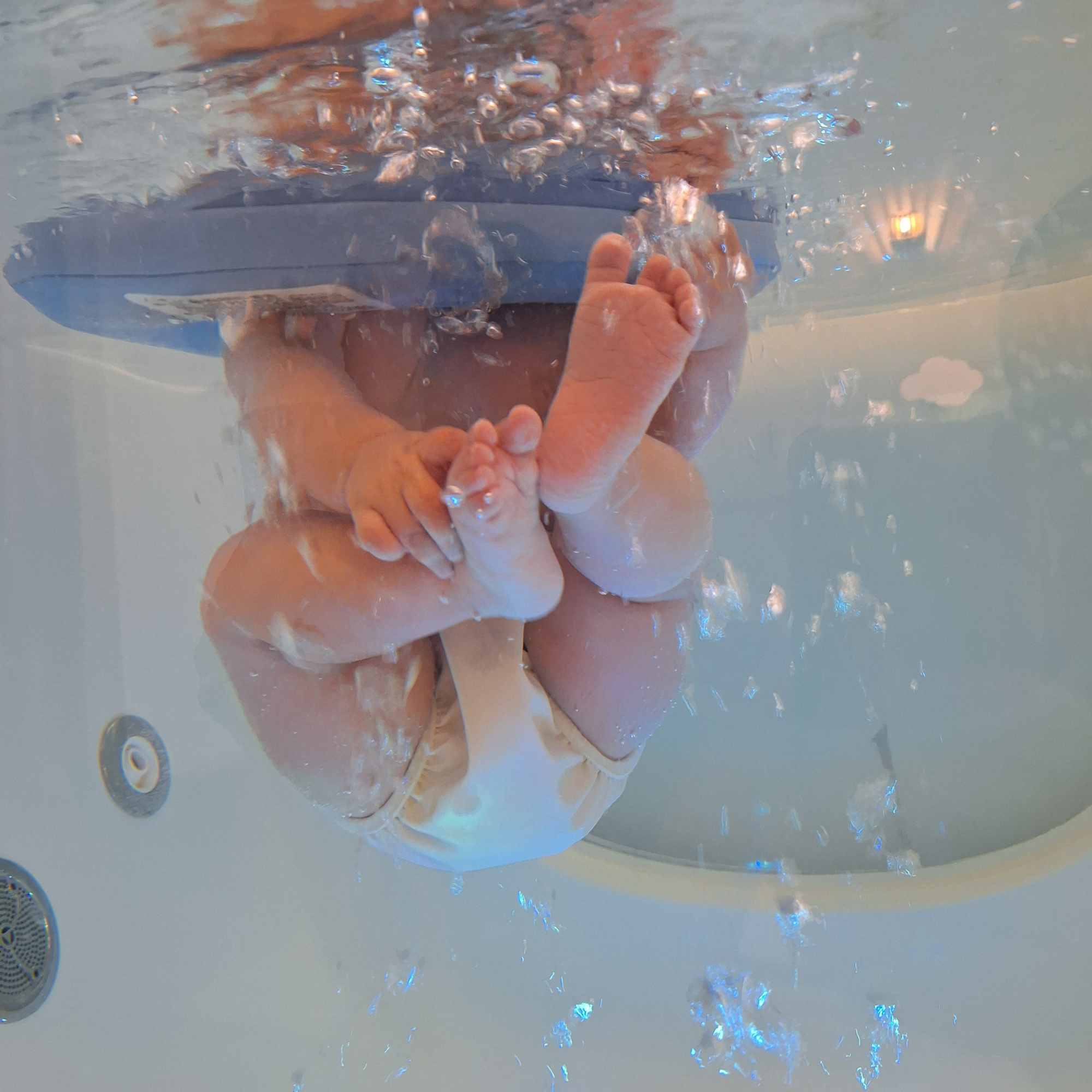 Bébé qui bouge librement dans l'eau, entouré de bulles