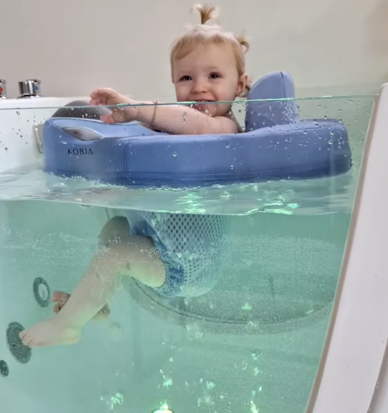 Bébé souriant dans un flotteur lors d'une séance de baby spa