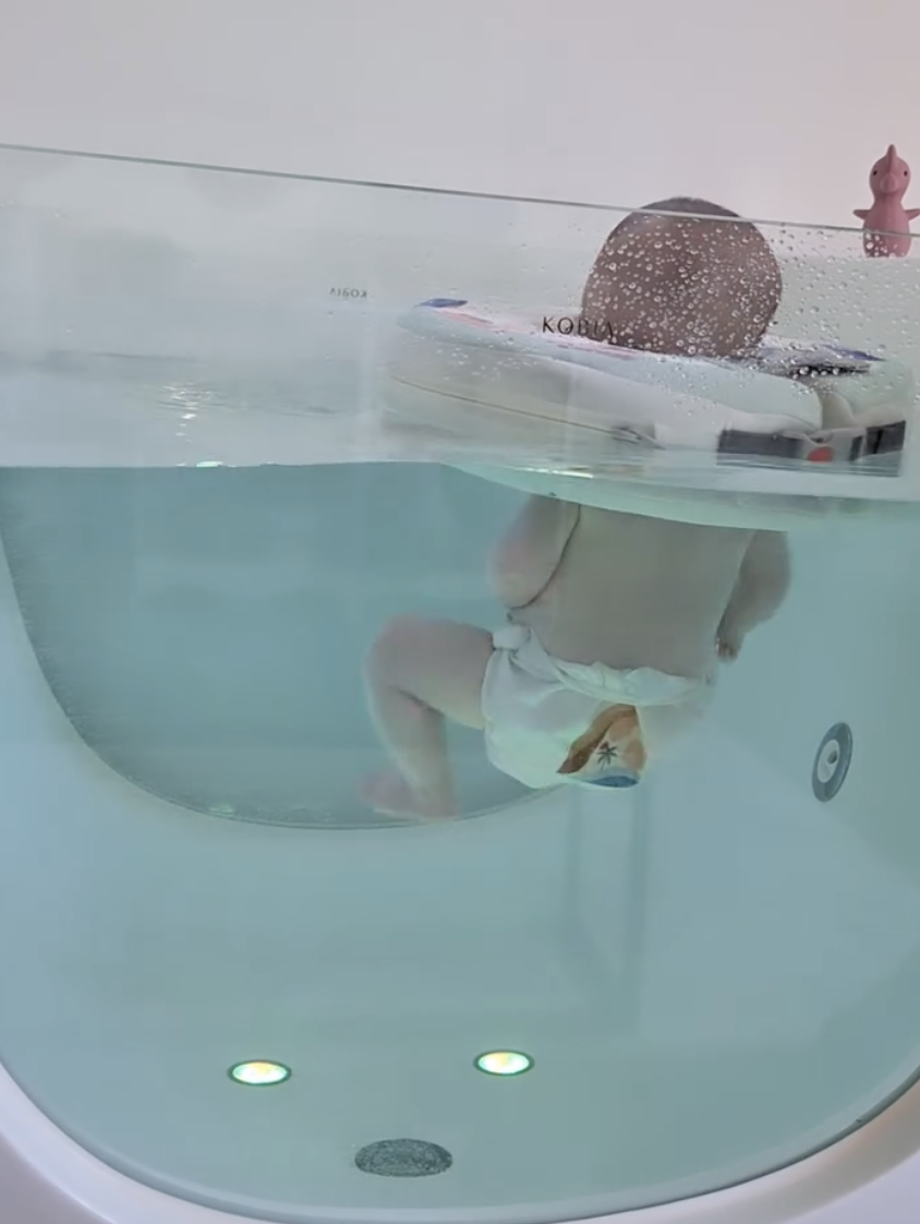 Bébé vu de dos évoluant librement dans l'eau